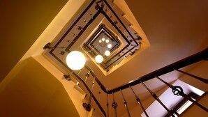 A spiral staircase with a metal railing and a central light fixture.