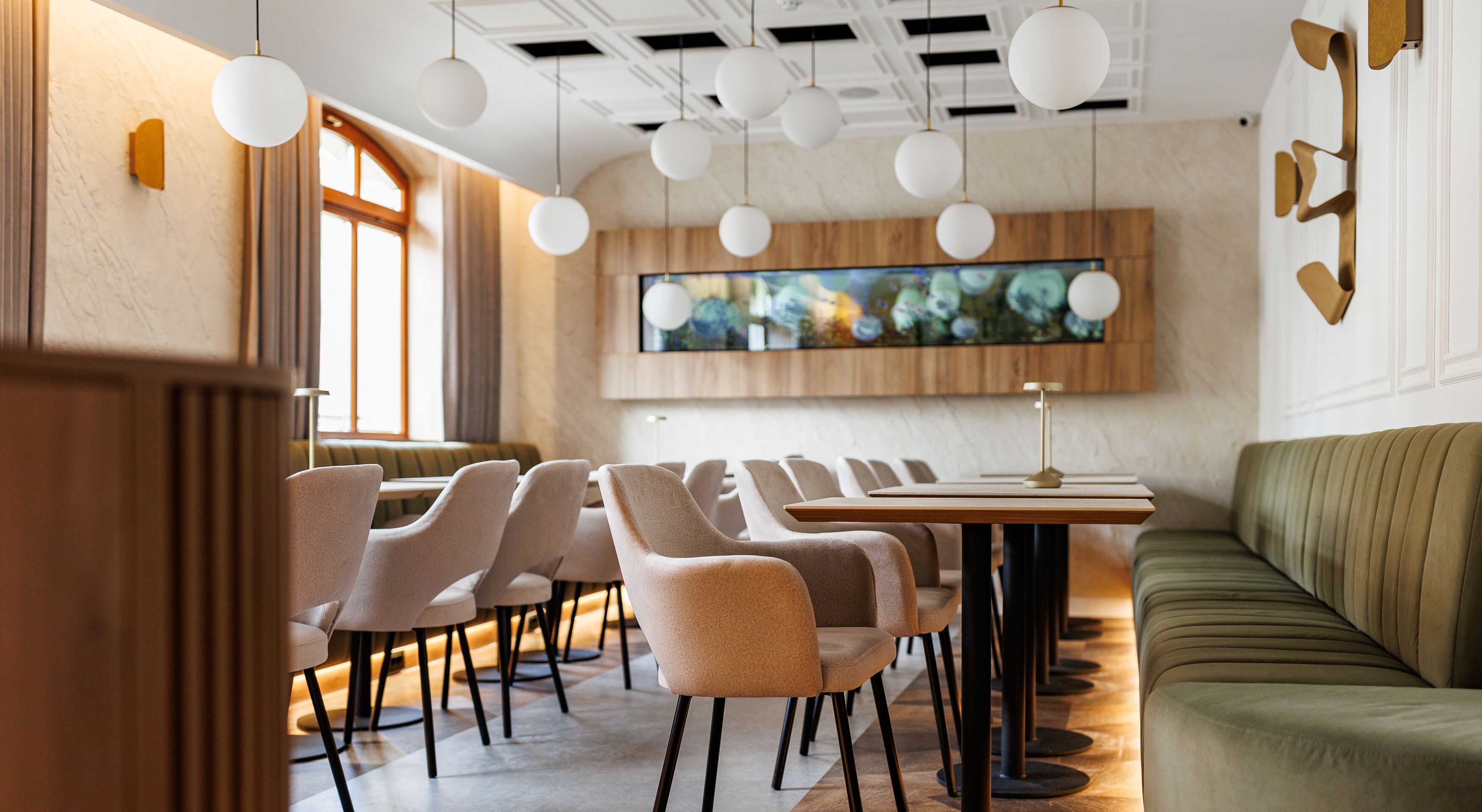 A modern dining area with a long table, multiple chairs, and a sofa.