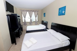 A hotel room with two beds, a TV, a desk, and a window with curtains. - Hotel Marvento Dos (Salinas)