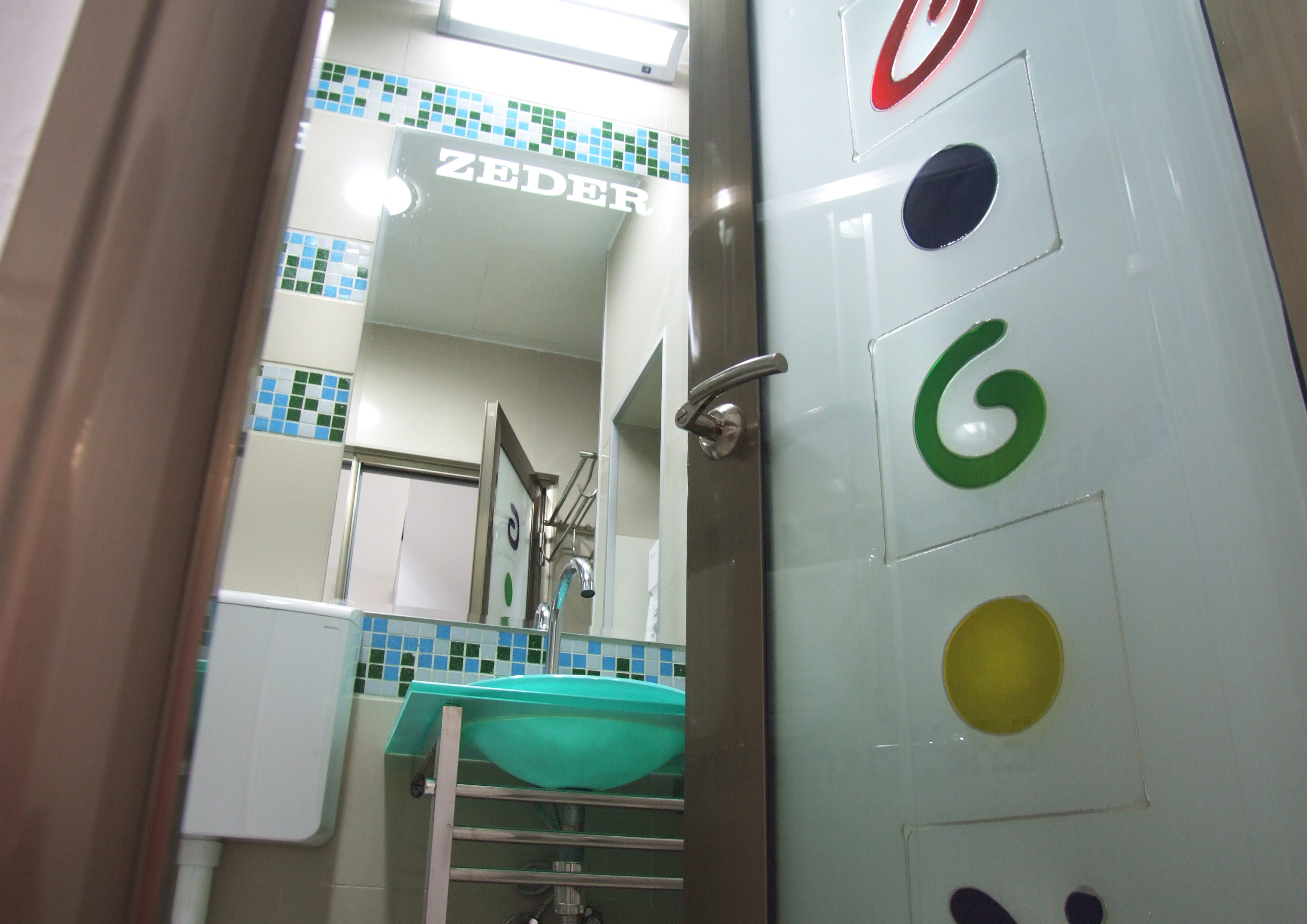 Un baño con lavamanos, espejo y paredes de azulejos.
