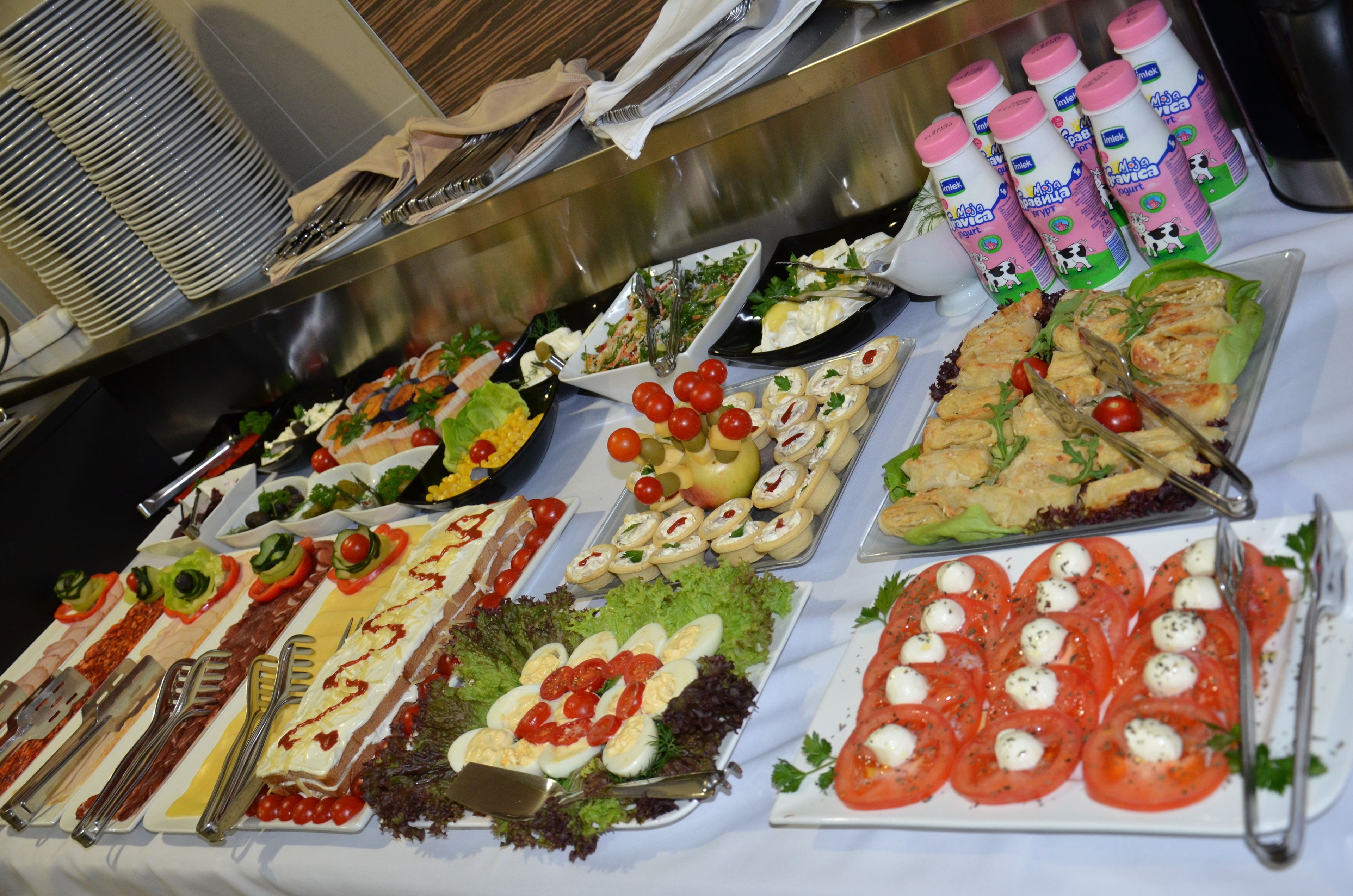 A buffet with various dishes and utensils.