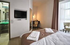 A hotel room with a bed, a desk, a chair, a television, and a bathroom with a sink and mirror. - Garni Hotel Zeder (Belgrade)