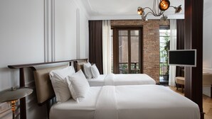 Une chambre d’hôtel avec deux lits, une télévision, un bureau et un balcon avec vue.