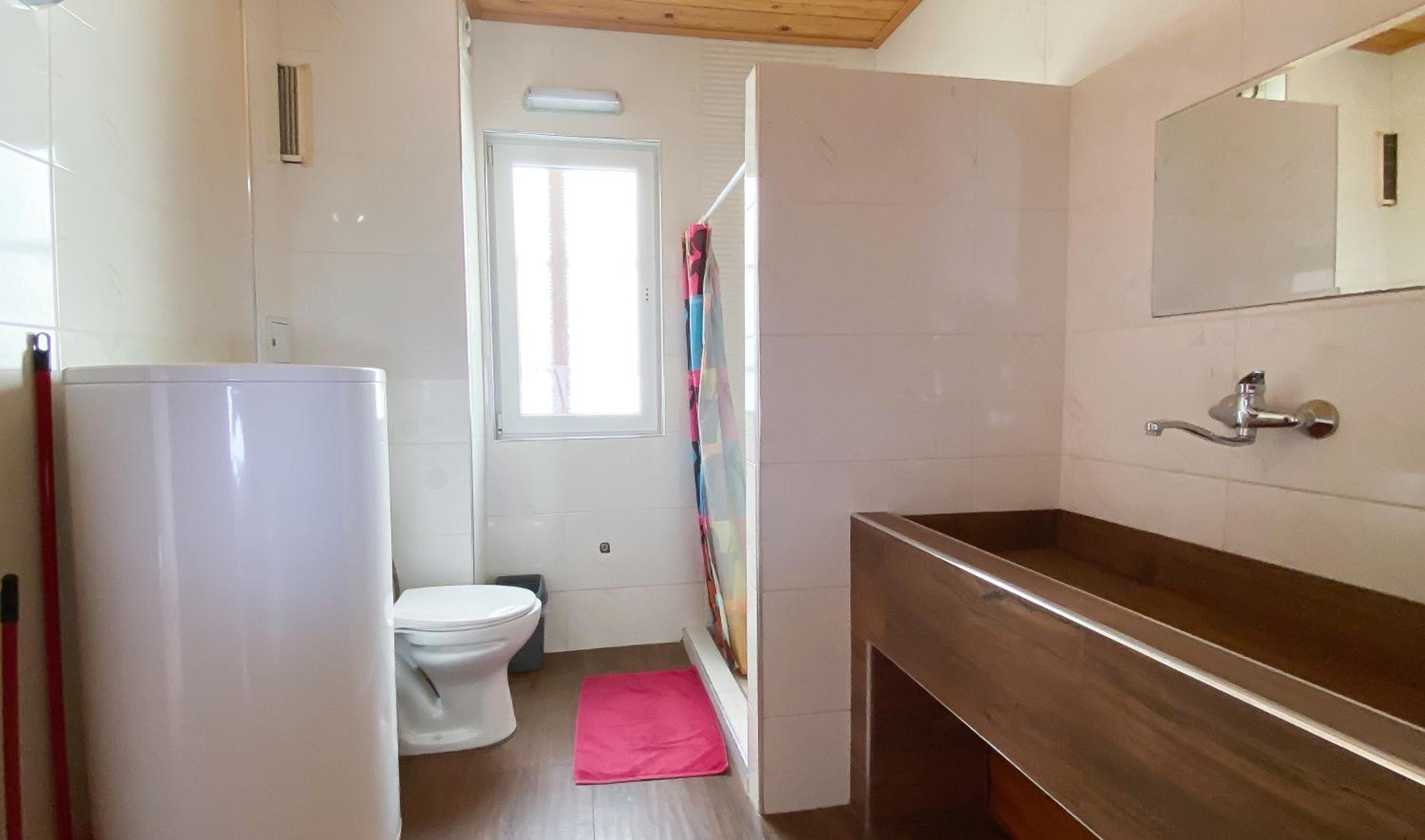 A bathroom with a white toilet, a sink, and a mirror.