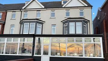 Vista frontal de la propiedad por la tarde o noche