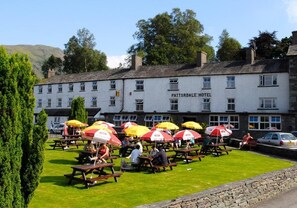 A Patterdale Hotel with outdoor seating and umbrellas. - Patterdale Hotel (Penrith)