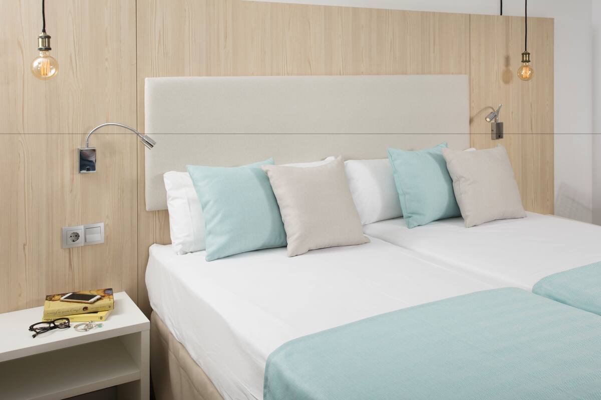 A modern bedroom with a large bed, two bedside tables, and a nightstand.