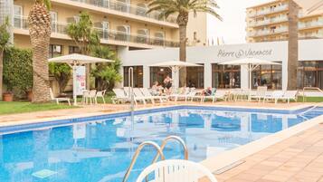 Una piscina al aire libre de temporada, tumbonas
