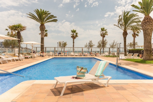 Una piscina al aire libre de temporada, sillones reclinables de piscina