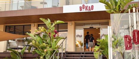 A building with a sign reading 'BOKAO' and a staircase leading to the entrance.