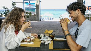 Dos personas cenando en una mesa con vista al mar.
