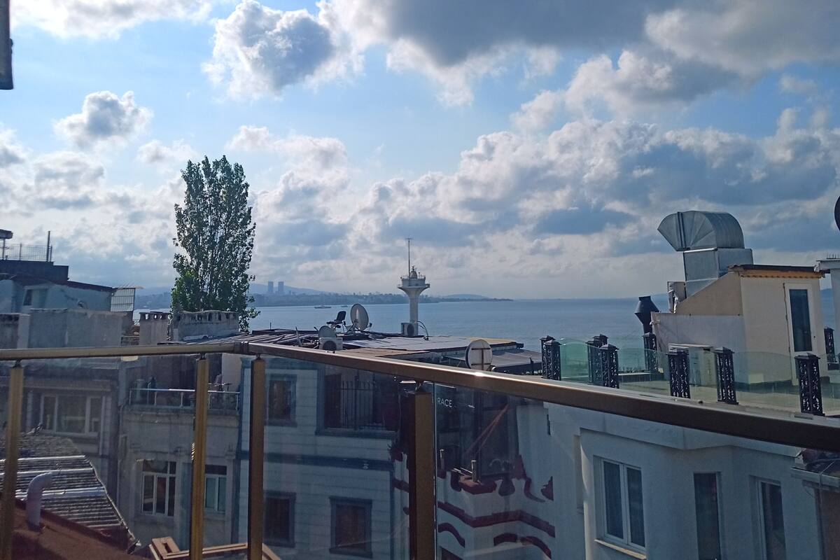 A rooftop with a view of the city skyline, including buildings and a tower.