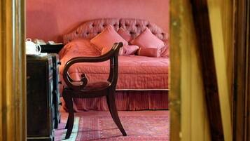 A bedroom with a bed, a chair, and a nightstand.