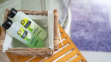 Un panier en osier contenant deux flacons de lotion pour le corps Alberto Balsam, parfum pomme verte.