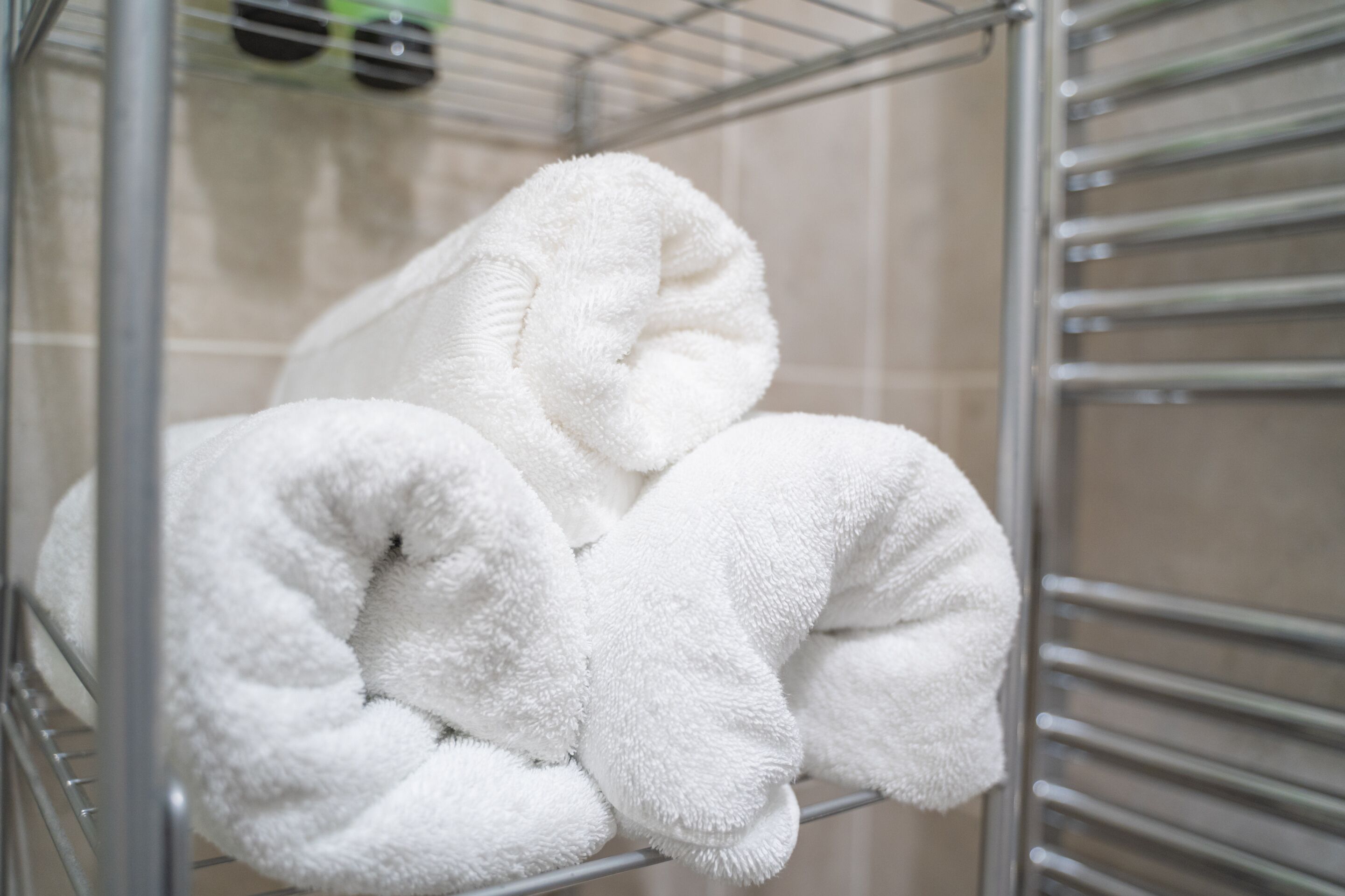 A metal rack holding several white towels.