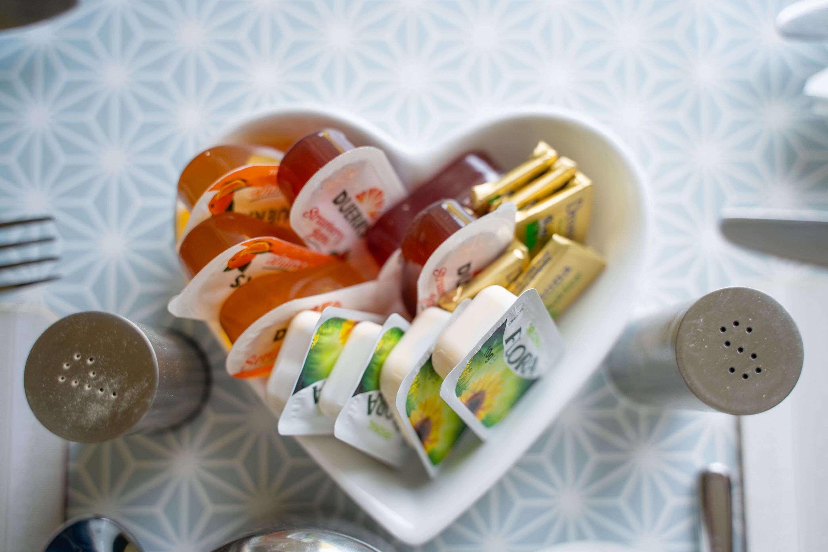 A heart-shaped bowl containing various food items and condiments.