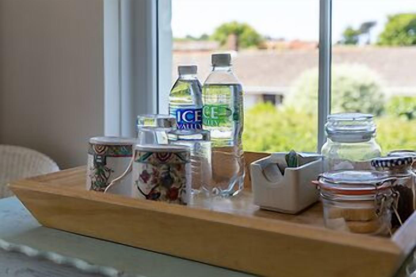 A tray with water bottles, a container labeled 'ICE', and a jar with a lid.