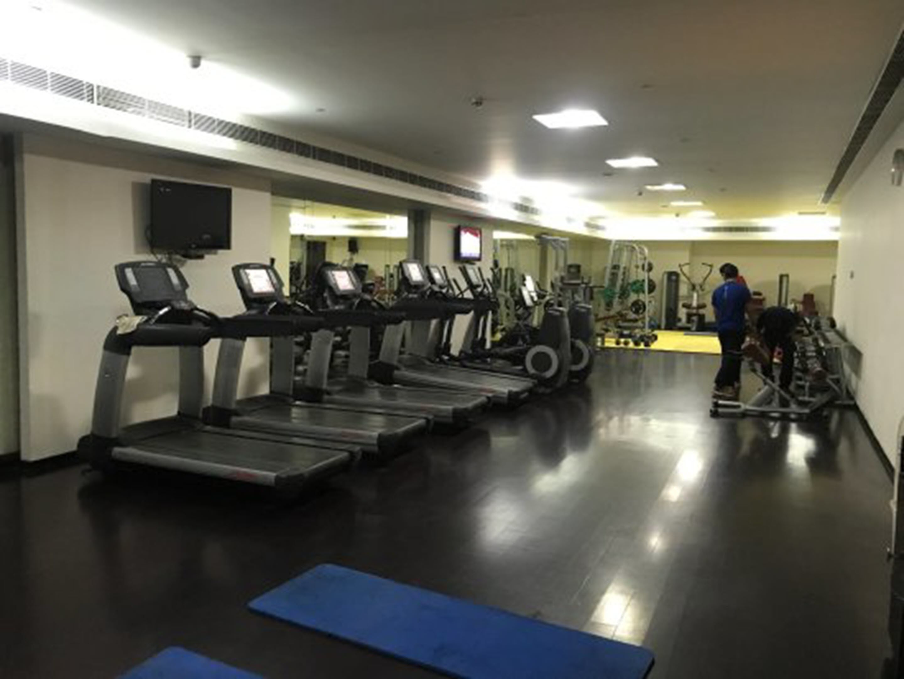 A gym with treadmills, exercise bikes, and weight machines.