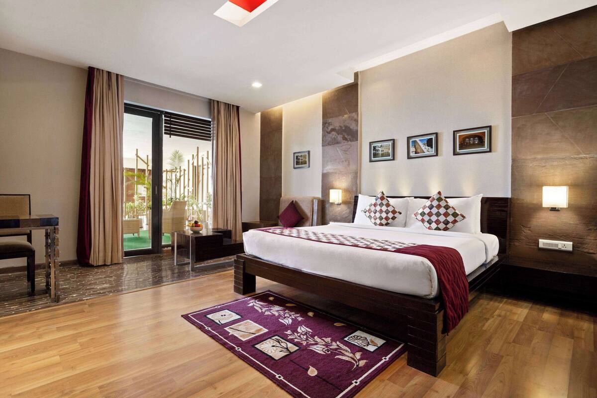 Une chambre d’hôtel moderne avec un grand lit, un bureau et une vue sur l’extérieur.