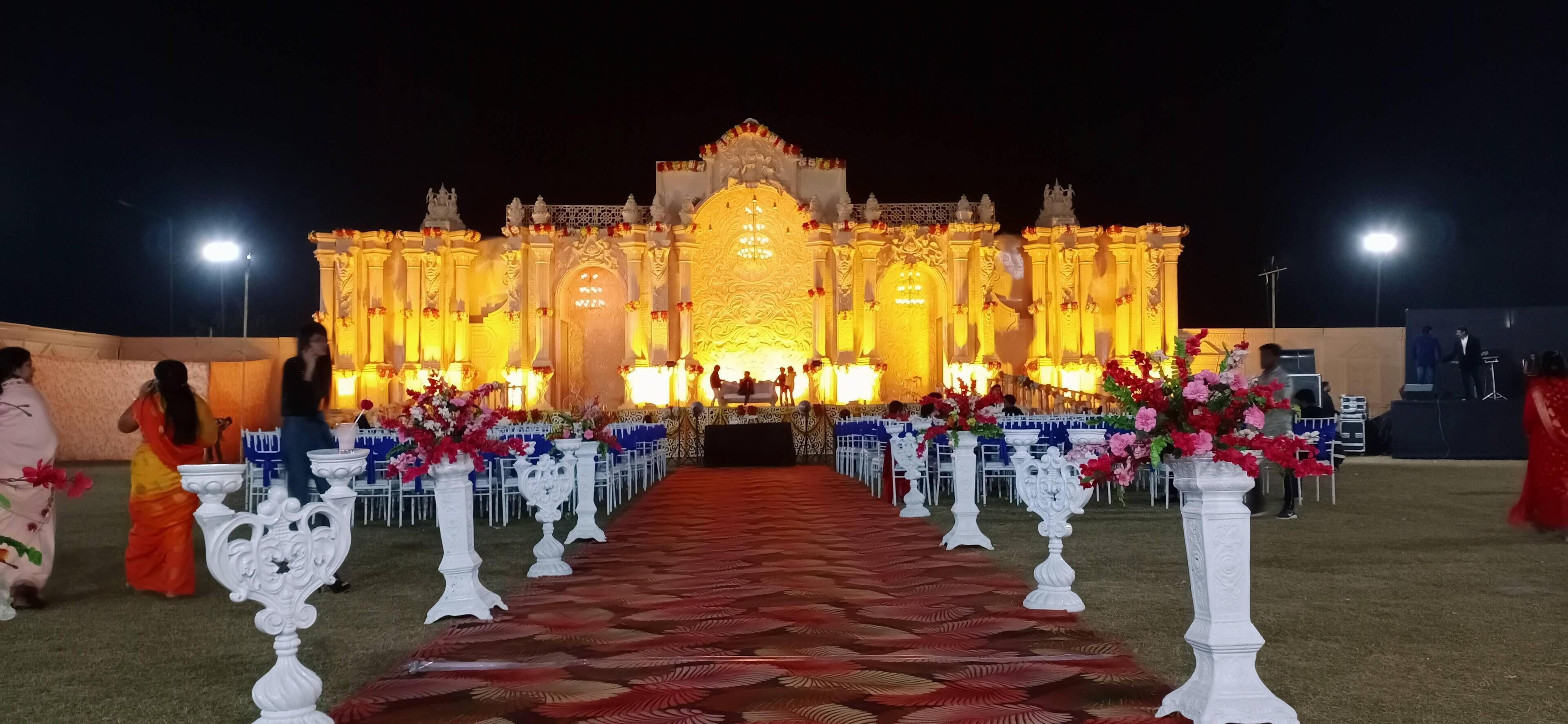 An outdoor event with a decorated stage and rows of chairs.