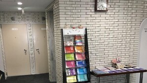 A room with lockers, a bulletin board, and a clock on the wall.