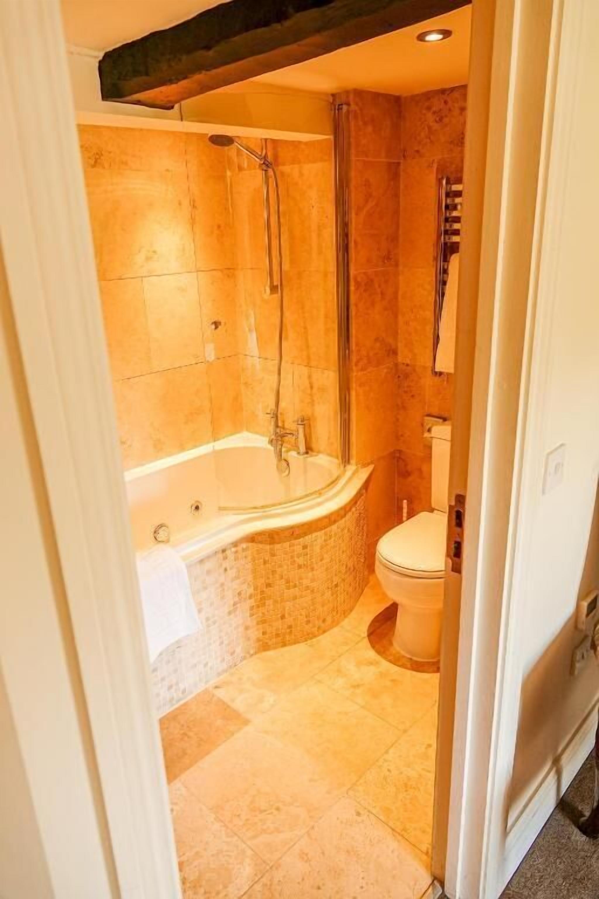 A bathroom with a glass-enclosed shower, a freestanding bathtub, and a toilet.