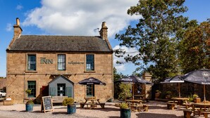 L’Auberge de Kingsbams, un bâtiment en pierre à l’architecture traditionnelle, dotée d’une terrasse et de places assises en plein air, ainsi que d’une cour en gravier.