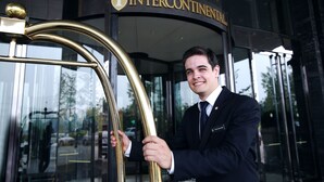 Un hombre con traje en la entrada de un edificio con un letrero que dice INTERCONTINENTAL.