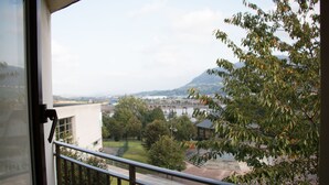 Un balcón con vistas a un paisaje urbano, que incluye edificios y un puente.