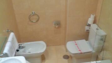 Een kleine badkamer met een wastafel, toilet en bad.