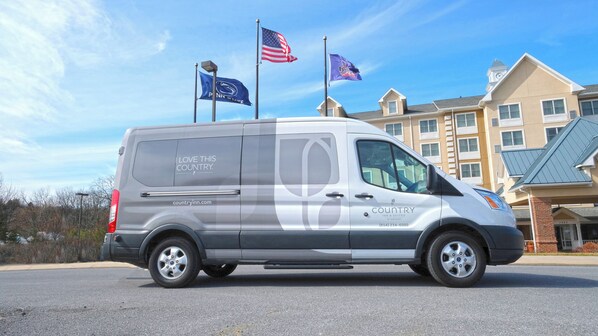 A Country Inn & Suites van parked in front of a building with a clock tower. - Country Inn & Suites by Radisson, State College (Penn State Area), PA (State College)