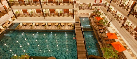 Una piscina al aire libre, sillones reclinables de piscina