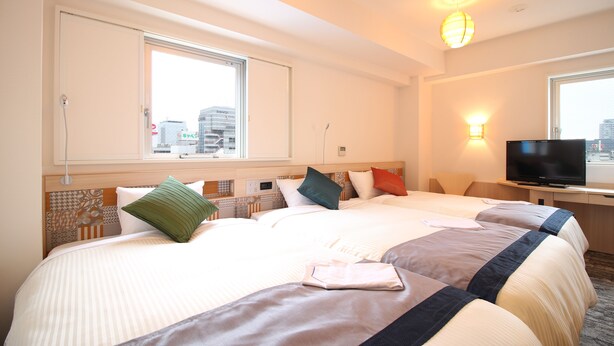 Une chambre d’hôtel avec deux lits, une télévision et une vue sur la ville.