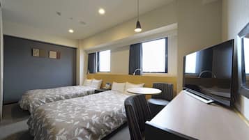 Een hotelkamer met twee bedden, een bureau, een stoel, een televisie en een raam met gordijnen.