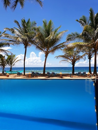 Una piscina al aire libre, sillones reclinables de piscina