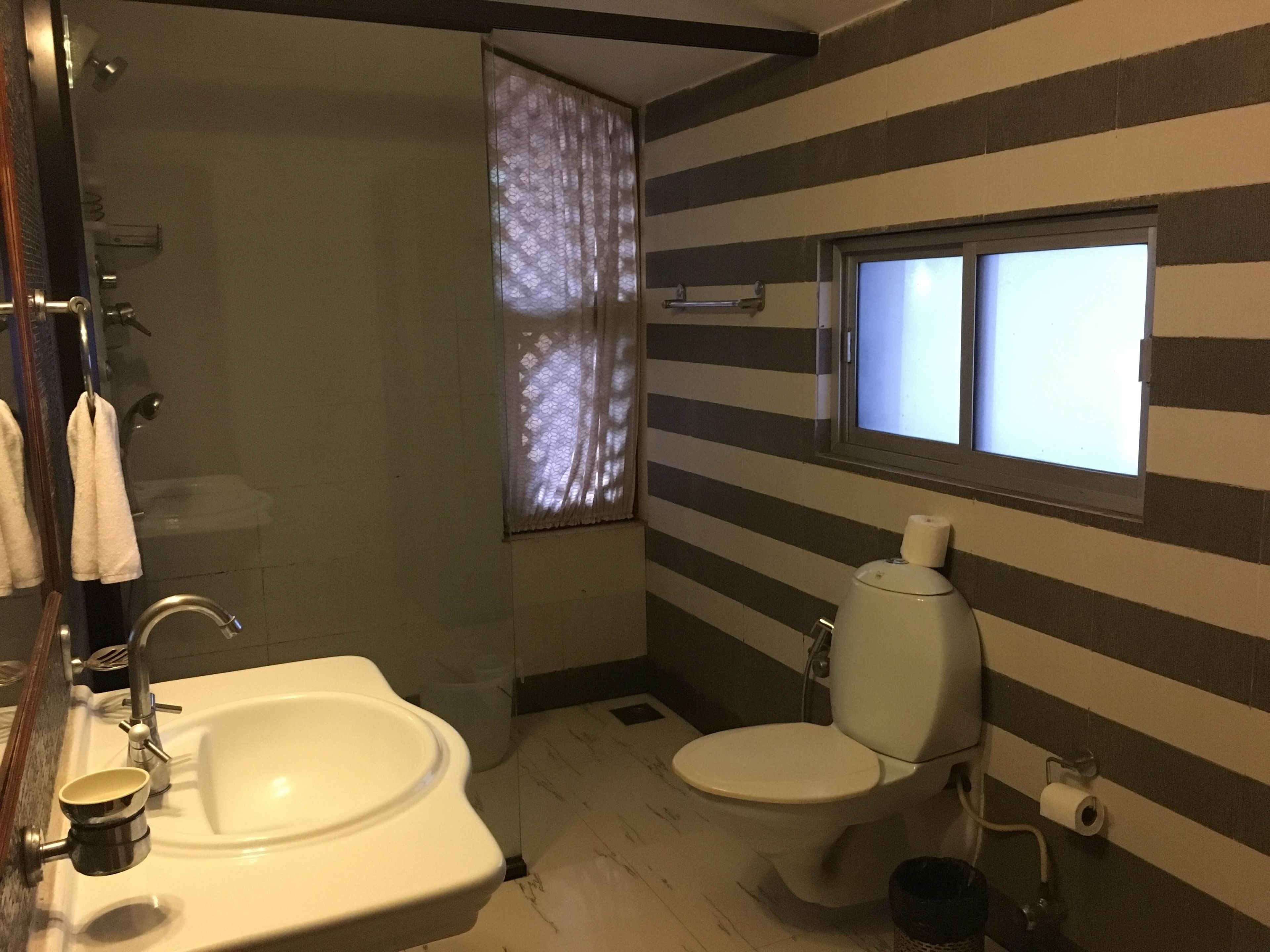 Casa de banho compacta com lavatório, sanita e janela.
