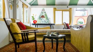 Una habitación con sofá, una mesita y una ventana con cortinas.