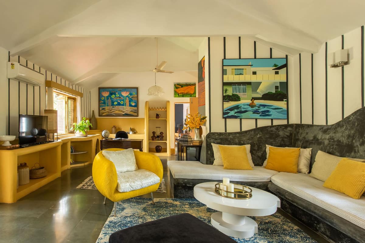 Uma sala de estar moderna com sofá, poltrona, mesa de centro e televisão.