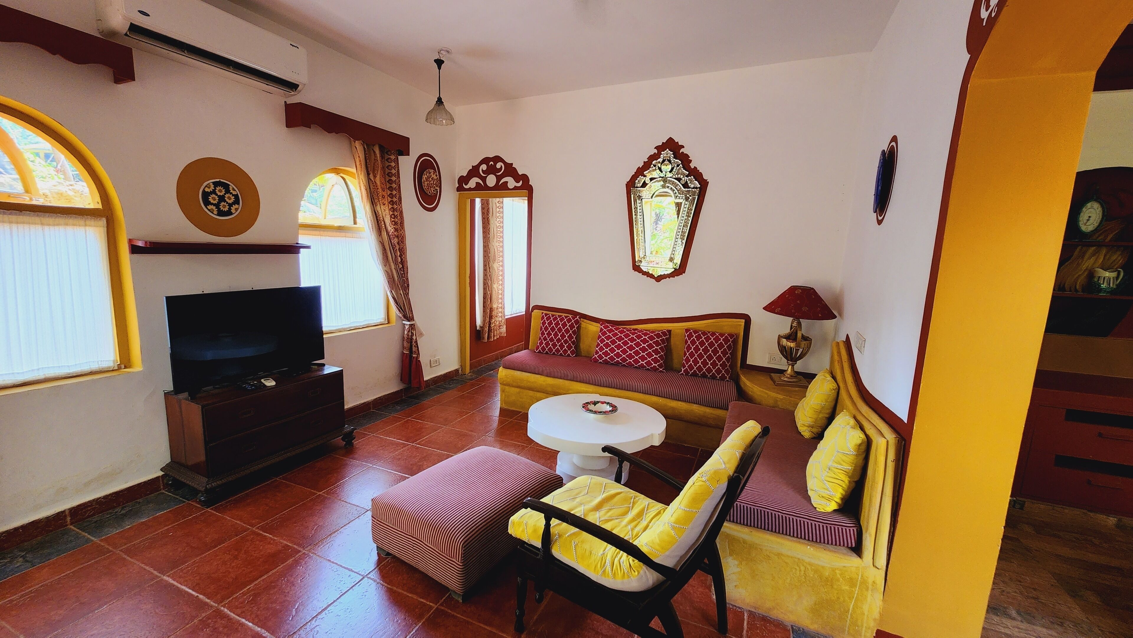 A living room with a sofa, a TV, a table, and a chair.