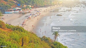 A beach with people, a boat, and buildings in the background. - Casa Anjuna (Anjuna)