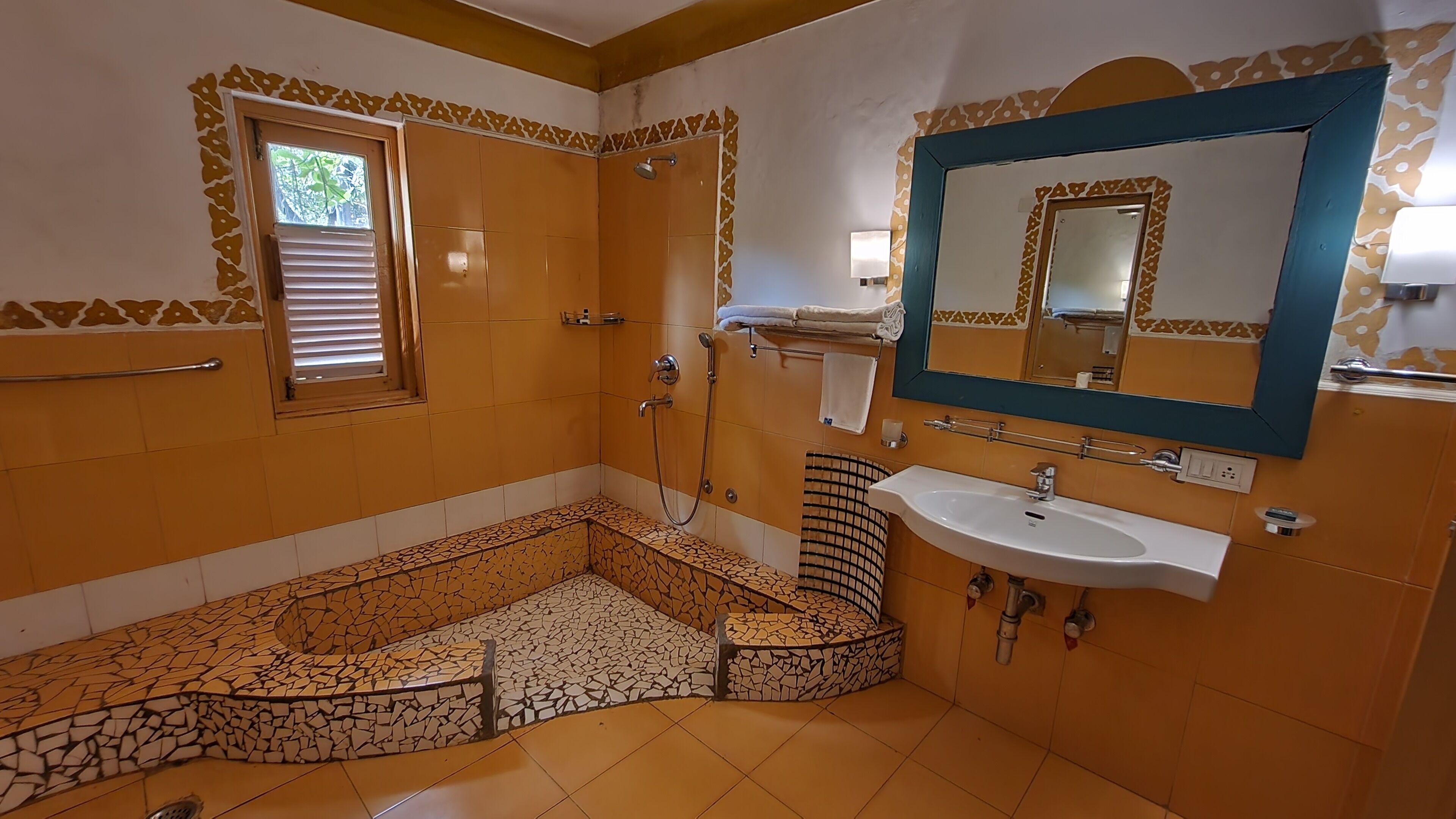 A bathroom with a shower, a sink, and a mirror.