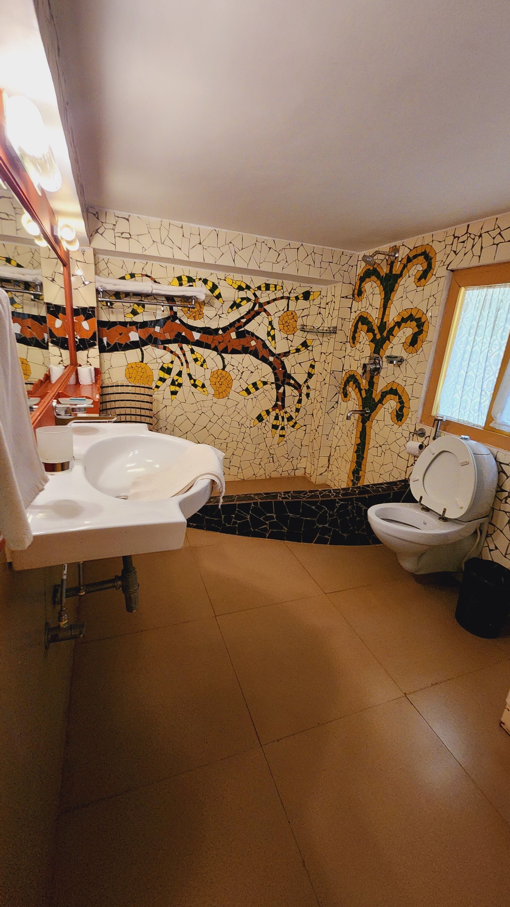 Un baño con pared de mosaicos, una bañera, un inodoro y un lavamanos.