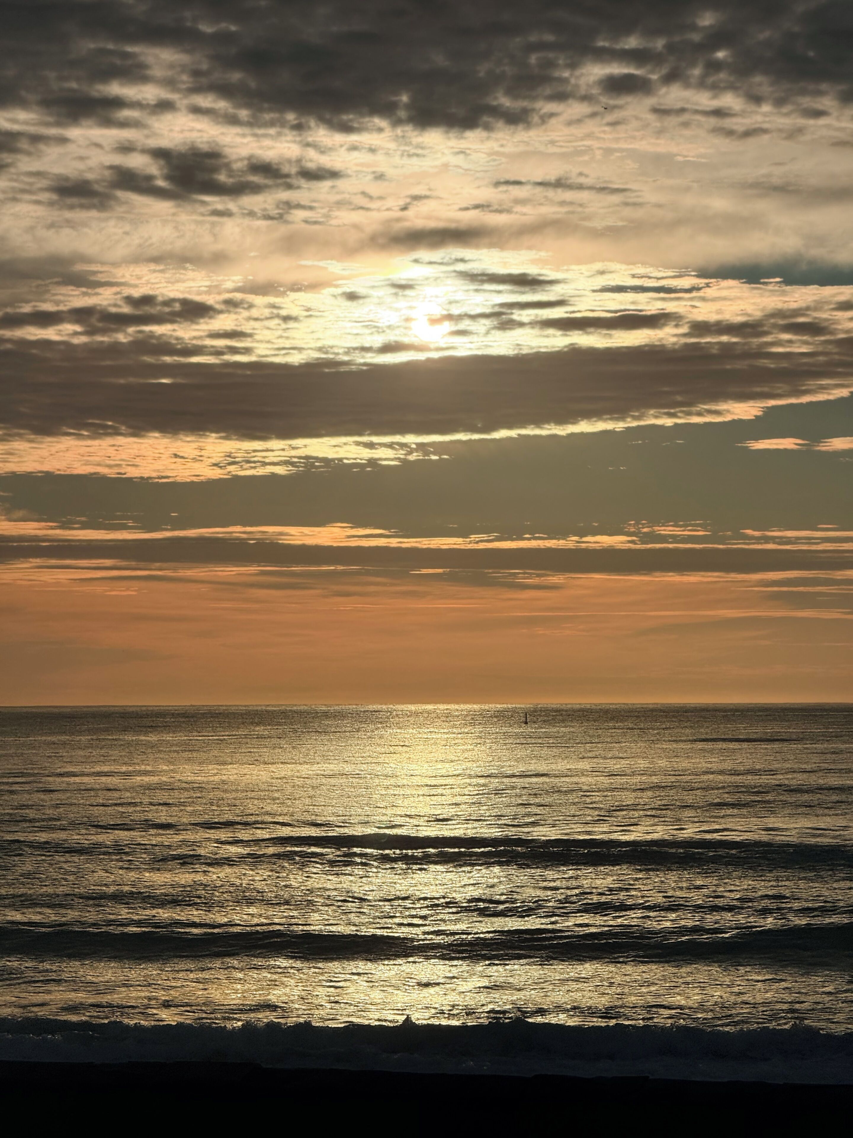 Un atardecer sobre un mar tranquilo con horizonte despejado.