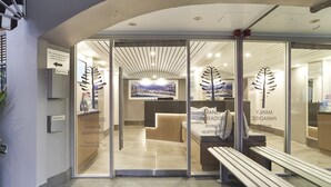 Un motel moderno con ingresso in vetro, una reception e vista sull'interno.