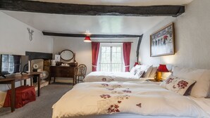 A bedroom with a large bed, a desk with a computer, a chair, and a window with curtains. - Yallands Farmhouse (Taunton)