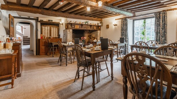A rustic dining area with wooden furniture and exposed beams. - Yallands Farmhouse (Taunton)