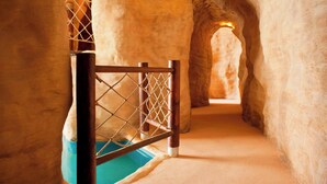 Un pasillo interior con una reja de madera y una zona de piscina.