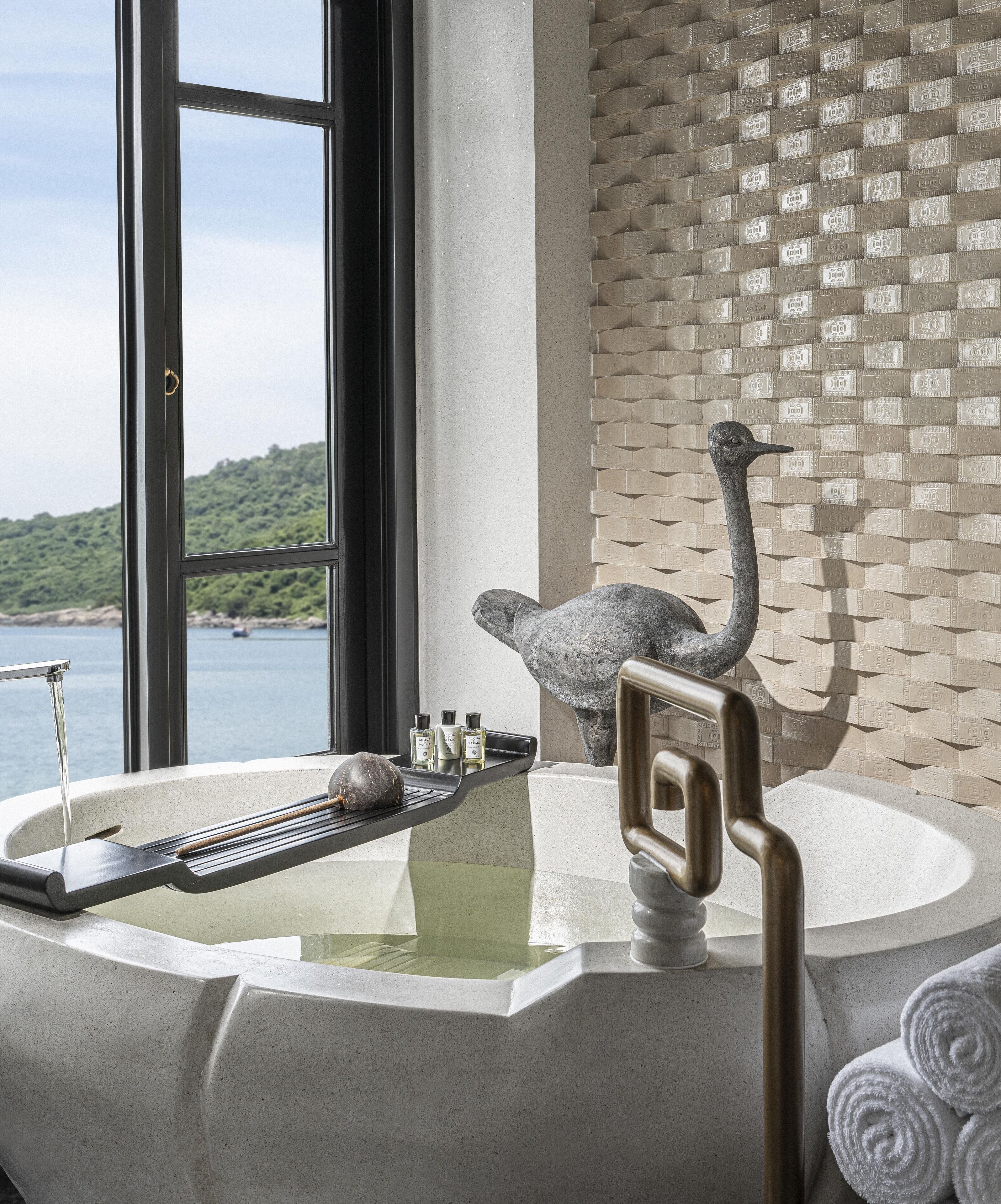 Ein Badezimmer mit einer Badewanne, einem Handtuchhalter und Meerblick.