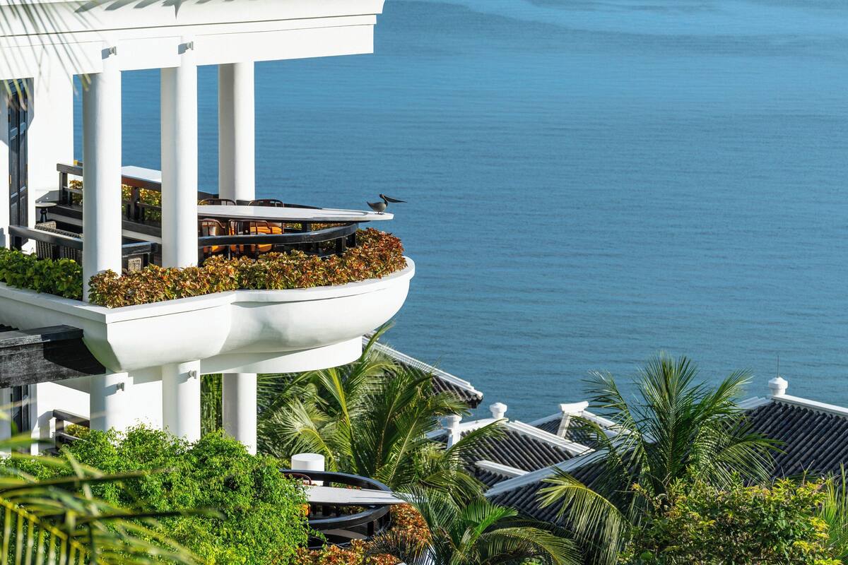 A modern building with a balcony overlooking a body of water.