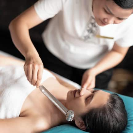 A person lying on a massage table receiving a treatment.